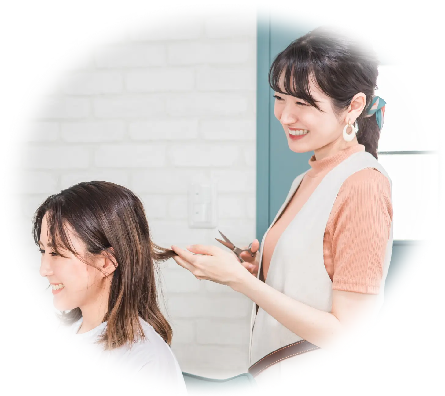 美容師が女性の髪をカットしている様子